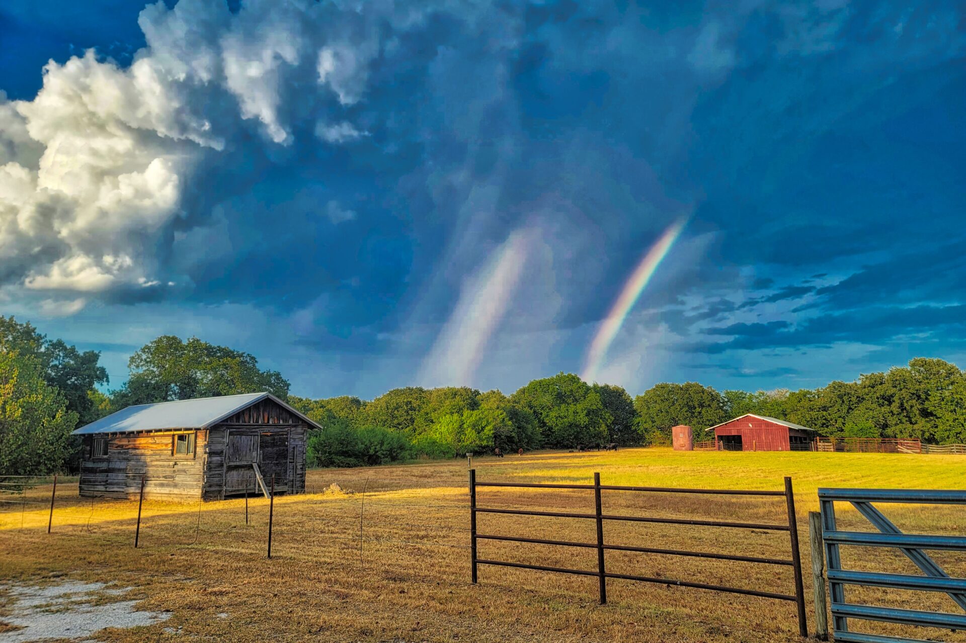 Aftermath of a Texas thunderstorm with sun beaming through the clouds producing a rainbow.