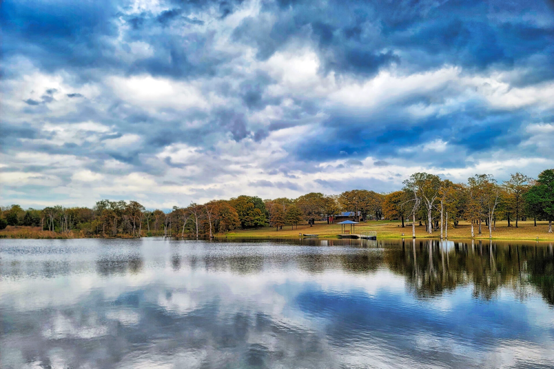 Cloudy sky reflected on a clear blue lake.