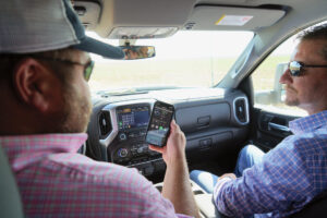 From the cab of his truck, Hughes, left, with Lone Star Ag Credit’s Jason Jones, can instantly monitor the status of many of his irrigation pivots.