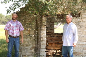 Aaron Nors and Hank Dawson in front of Rogstads’ original one-room stone cabin