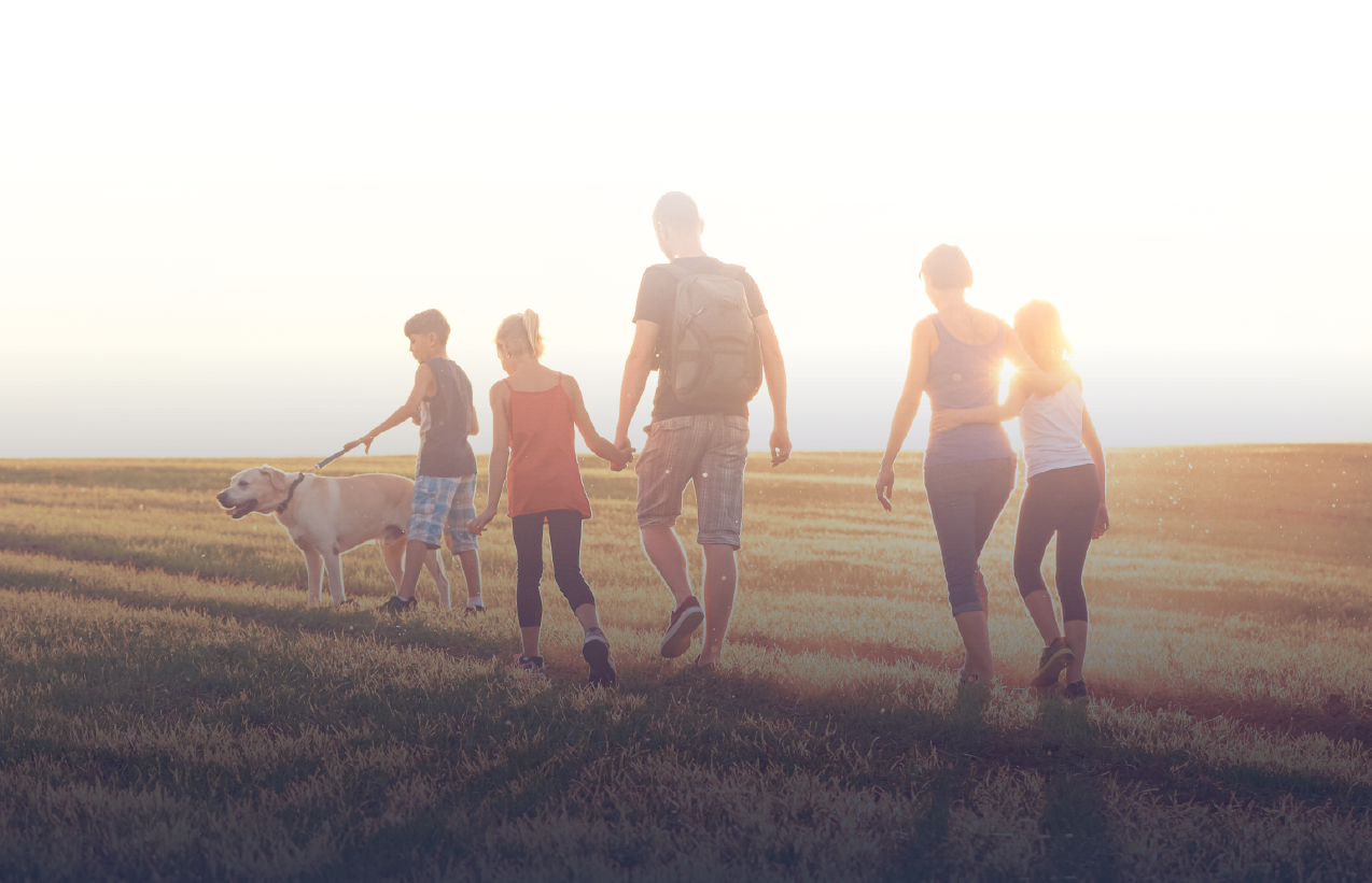 Family walking across a field as the sun rises in Texas