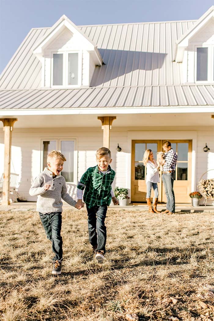 Parents and two kids in front of home.