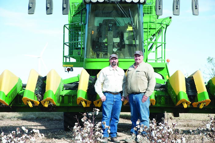 AgTrust Farm Credit cotton farming customers, the Petty brothers, standing in front of equipment.